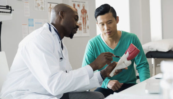 Doctor and patient examining bone model in clinic