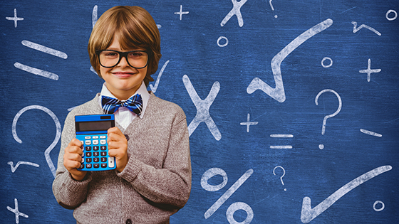 Schoolboy holding calculator in front of a chalkboard