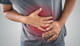 The photo of large intestine is on the man's body against gray b