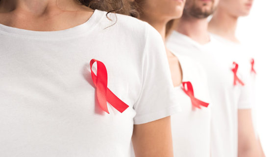 cropped image of people standing with red ribbons on white shirt