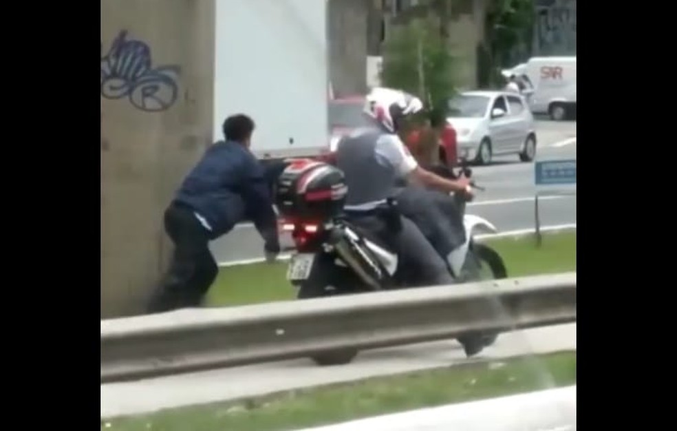Vídeo mostra PM arrastando homem negro algemado na moto em SP