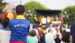 Young boy with Venezuelan pullover watching a stage at Venezuela