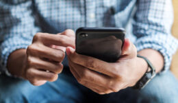 Young casual Businessman holding and using smartphone for sms me