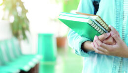 Student girl holding books and carry school bag while walking in