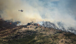 Firefighting helicopter drop water on forest fire