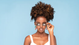 Afro woman wearing sunglasses and earrings.