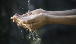 closeup water flow to hand of women for nature concept on the ga