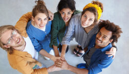 Friendly people of different races looking from above holding their hands together embracing each other rejoicing their victory. Diversity, teamwork, cooperation, ethnicity and people concept