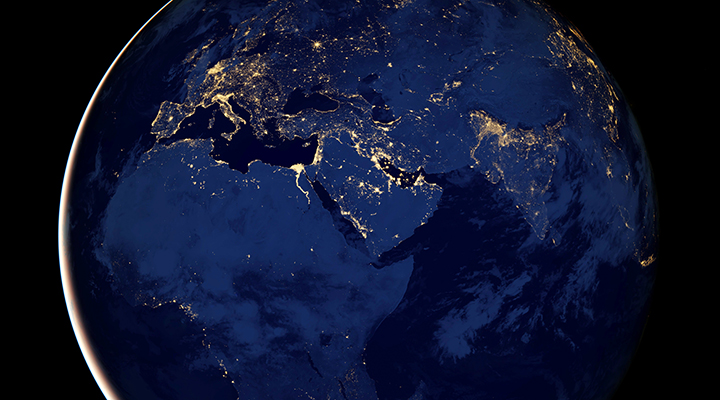 Foto tirada do espaço, de parte do Planeta Terra, à noite. O hemisfério norte do globo tem mais pontos luminosos do que o sul. | Estudo mostra que pobreza pode ser vista do espaço