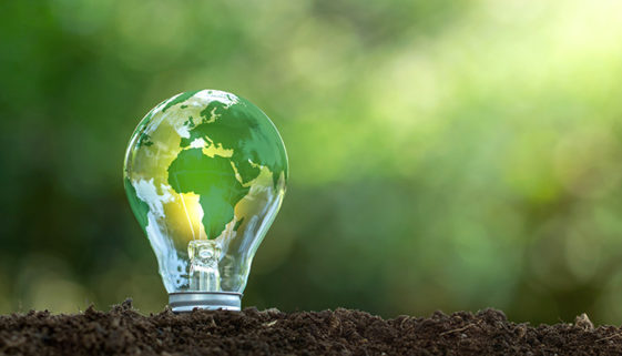O mapa do mundo verde está em uma lâmpada que representa energia verde, energia renovável.