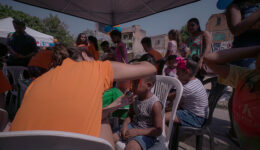 Foto de crianças durante recreação, tendo seus rostos pintados.
