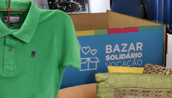 Caixa de doações ao lado de camisa que faz parte de bazar