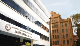 Foto da fachada da Faculdade de Ciências Médicas da Santa Casa de São Paulo. É um prédio branco com janelas escuras.