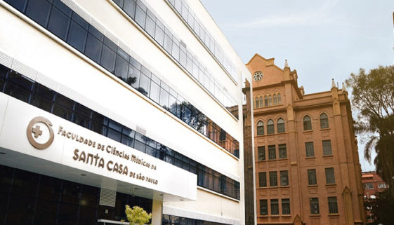 Foto da fachada da Faculdade de Ciências Médicas da Santa Casa de São Paulo. É um prédio branco com janelas escuras.