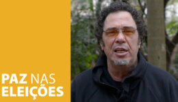 Uma faixa amarela cobre menos da metade da imagem e possui o texto "PAZ NAS ELEIÇÕES", escrito em branco. Walter Casagrande aparece na outra parte da foto.