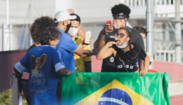 Mulher discursa em microfone junto à bandeira do Brasil