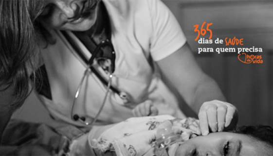Foto em preto e branco de uma profissional de saúde consultando uma criança deitada.