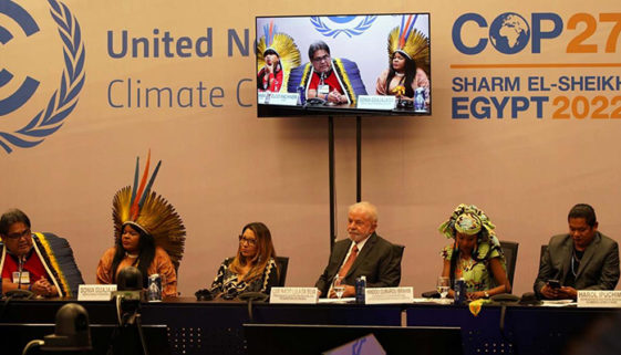 Foto de seis pessoas sentadas à mesa em painel de reunião entre países do mundo.