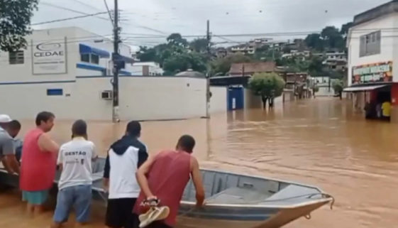 Voluntários usam barco para levar água e comida às vítimas da enchente no RJ