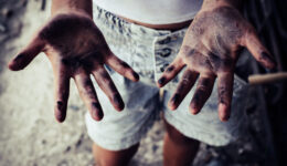 Dirty hands of children from construction work. World Day Against Child Labour concept.