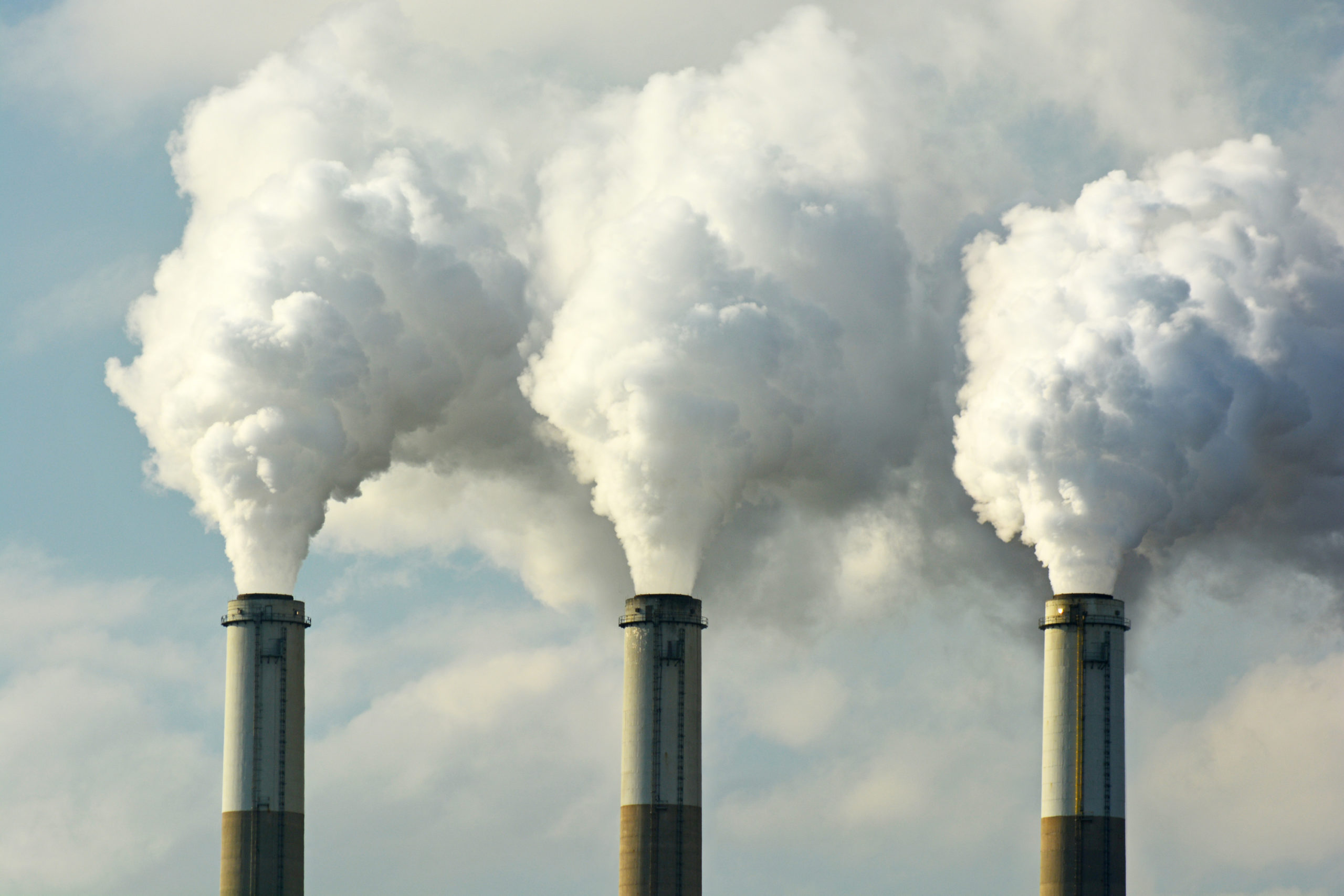Multiple Coal Fossil Fuel Power Plant Smokestacks Emit Carbon Di