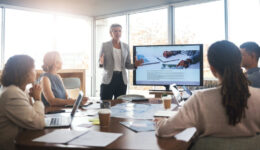 Business leader, woman and slideshow at team building seminar for company growth. Working, market research data and workshop of a female manager meeting with marketing group in office with tech