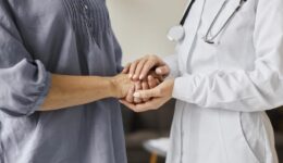 medica-centro-de-recuperacao-covid-segurando-as-maos-de-uma-paciente-mais-velha