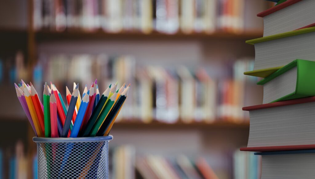 Digital composite of Pencils and stack of books with library background