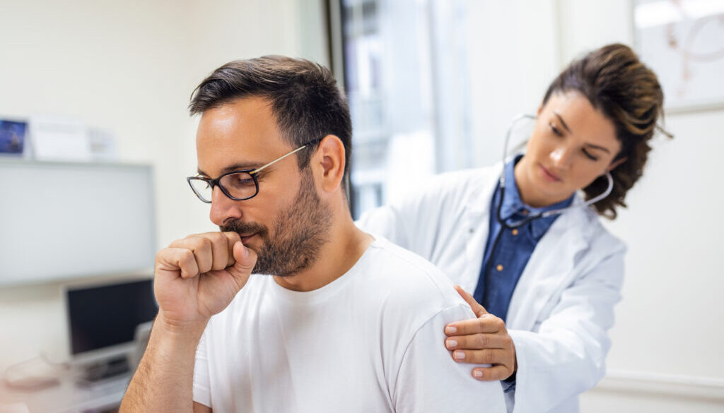 A female doctor at the clinic performs auscultation of the lungs of a patient with symptoms of coronavirus or pneumonia.